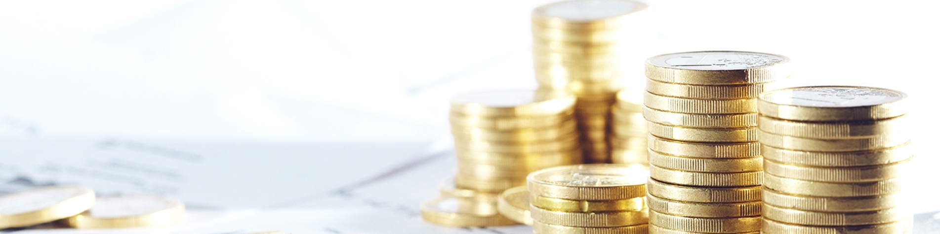 Seks stakke af mønter på bord oven på papirer