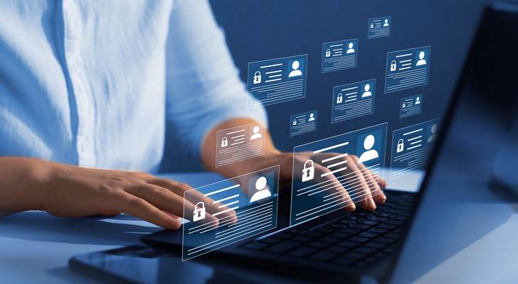 Mand sidder ved bærbar med personoplysninger hængene over