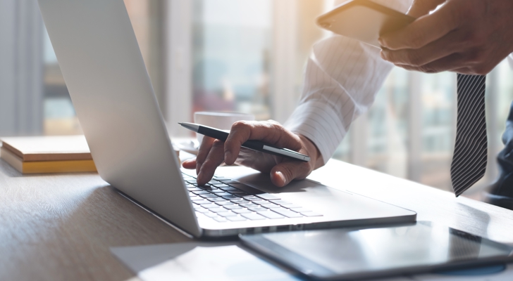 Mand holder computer og telefon