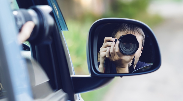 Person sidder i bil og overvåger med kamera