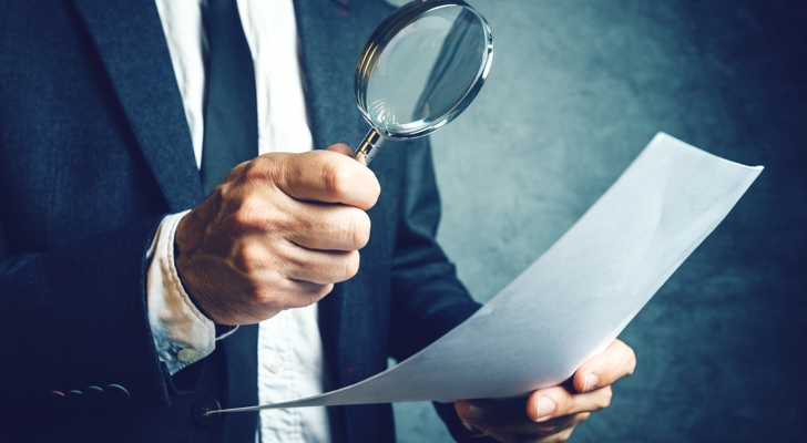 Person undersøger dokument med loop