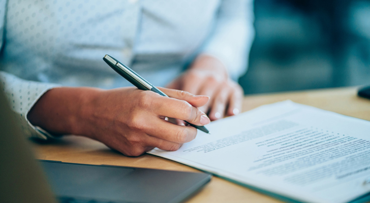 Kvinde underskriver dokumenter